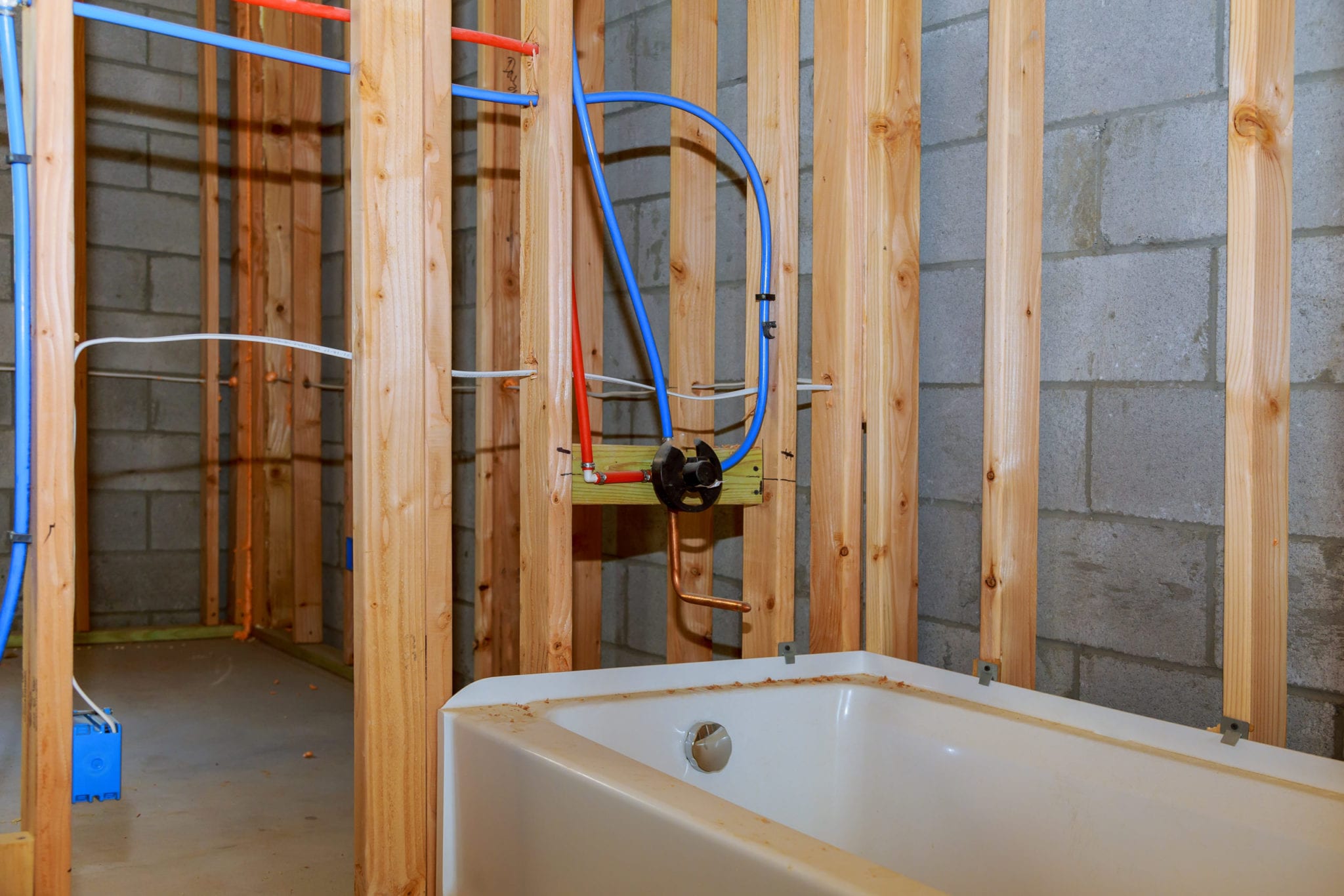 Bathroom remodel showing under floor plumbing work connecting old copper pipes to new plastic ones Remodeling a home bathroom, installation of pipes for water for new buildings