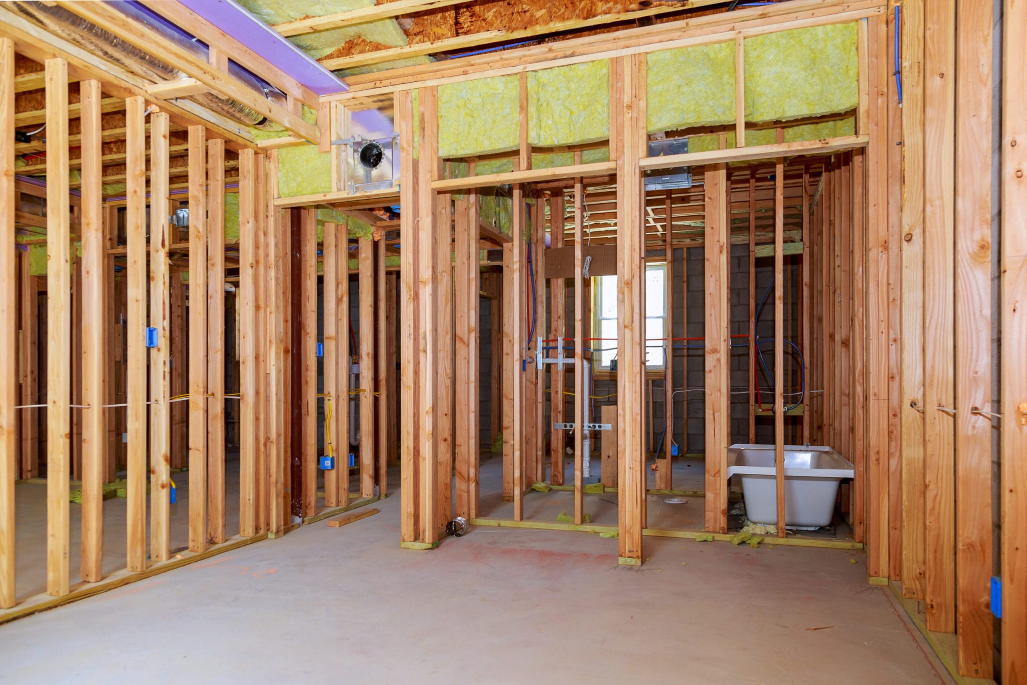 Interior wall framing with piping installation in the basement Bathroom remodel showing under floor plumbing work