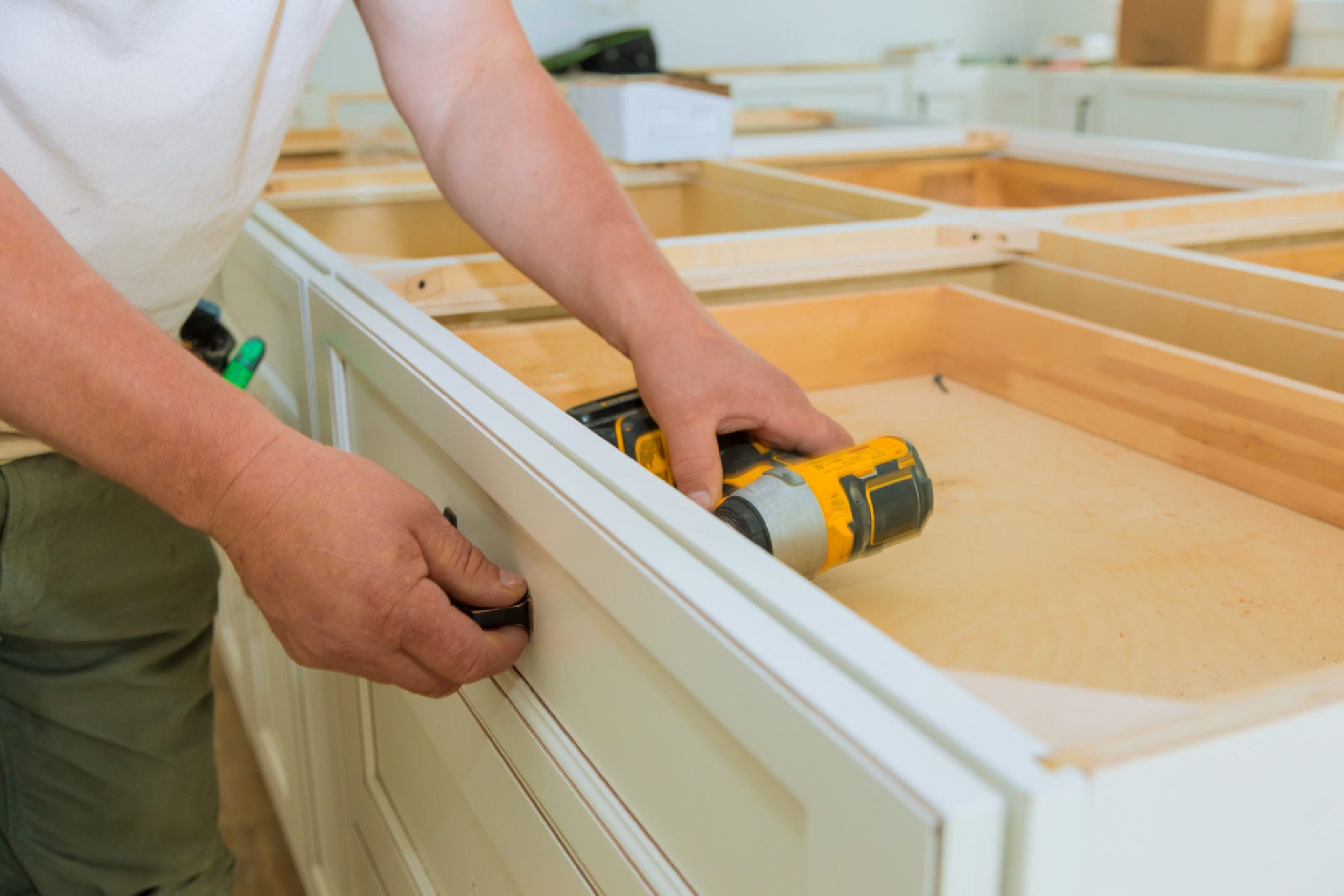 Installation of measuring drawers handles on kitchen cabinets