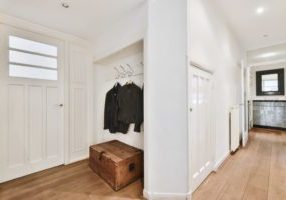 The entrance part of the apartment with a hanger and a wooden chest