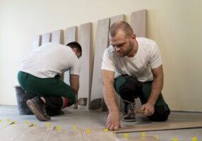 full-shot-workers-tiling-floor-indoors